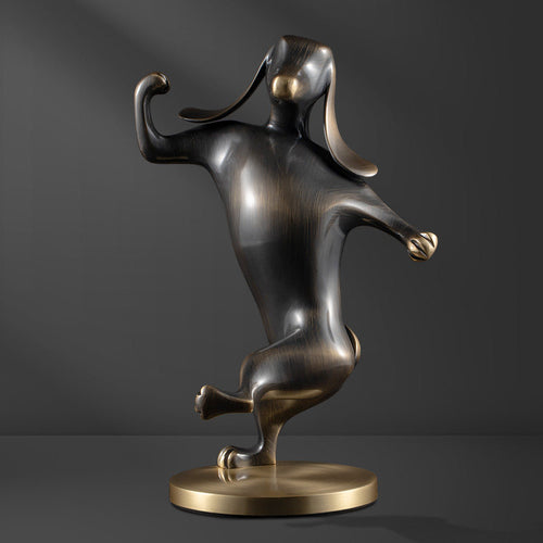 Front view of dancing dog sculpture in antique brass