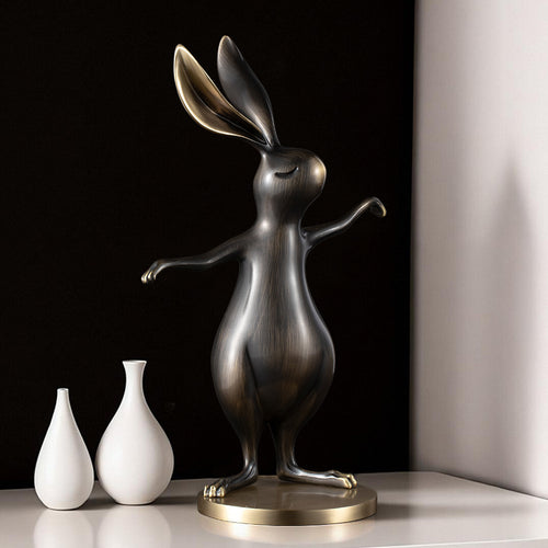 Stylized brass rabbit figurine on table with vases