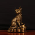 Front view of antique copper cat sculpture on coins