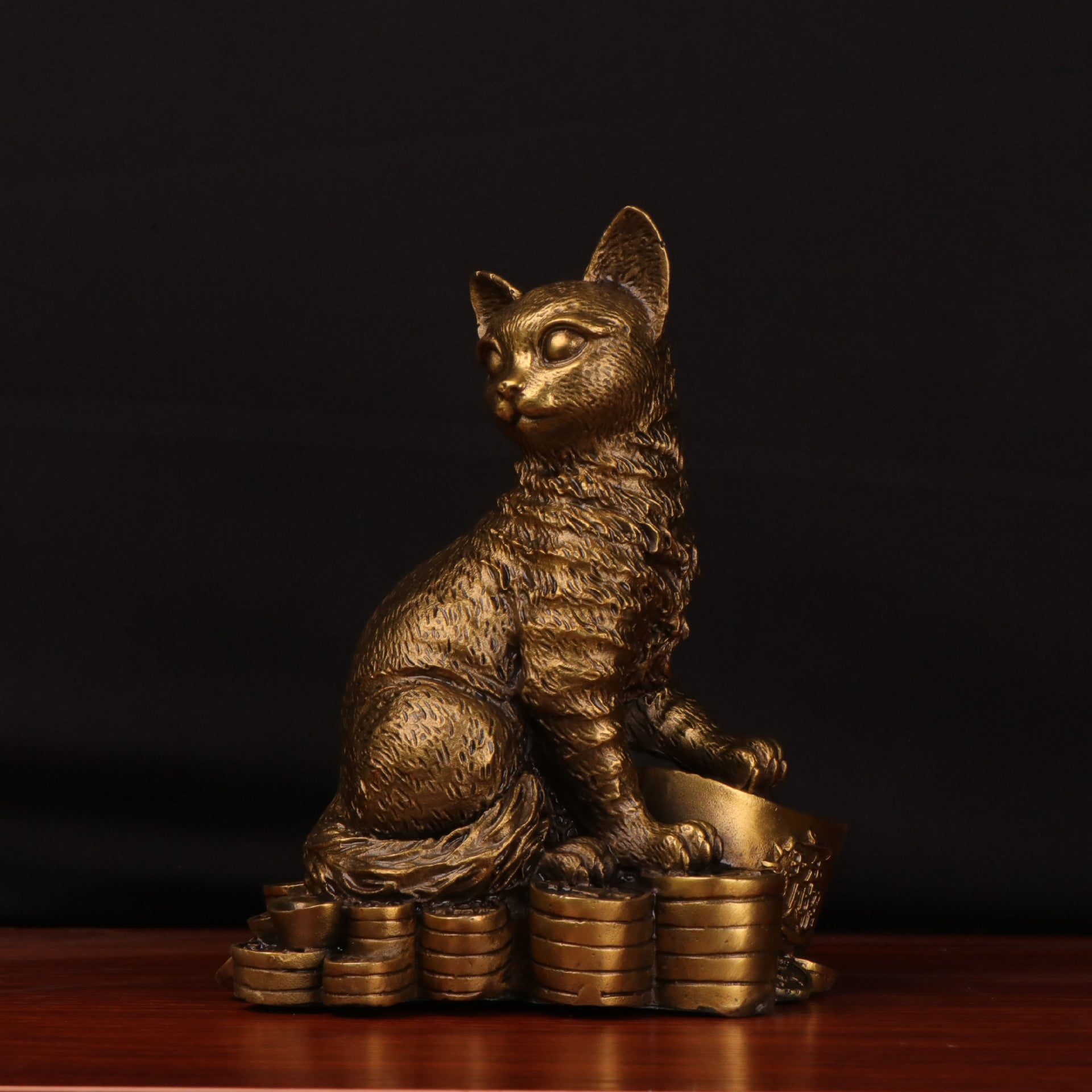 Front view of antique copper cat sculpture on coins