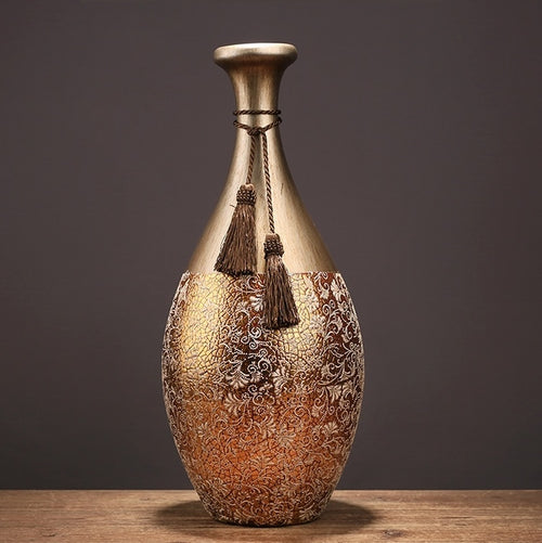 Tall antique gold vase with floral relief and tassel