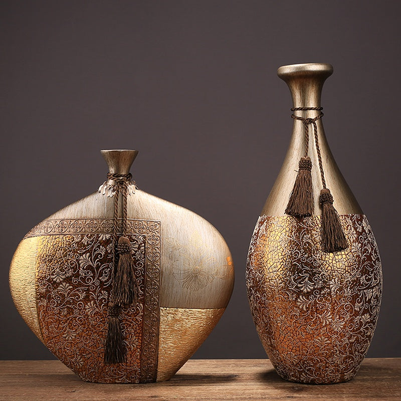 Set of two luxury gold resin vases on wooden table