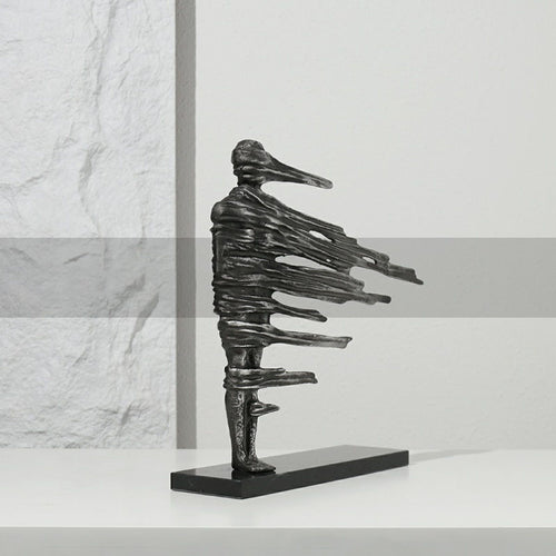 Side profile of antique silver wind-swept figure sculpture on black base