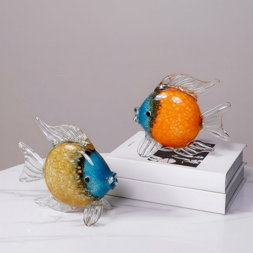 Two art glass fish sculptures on a book