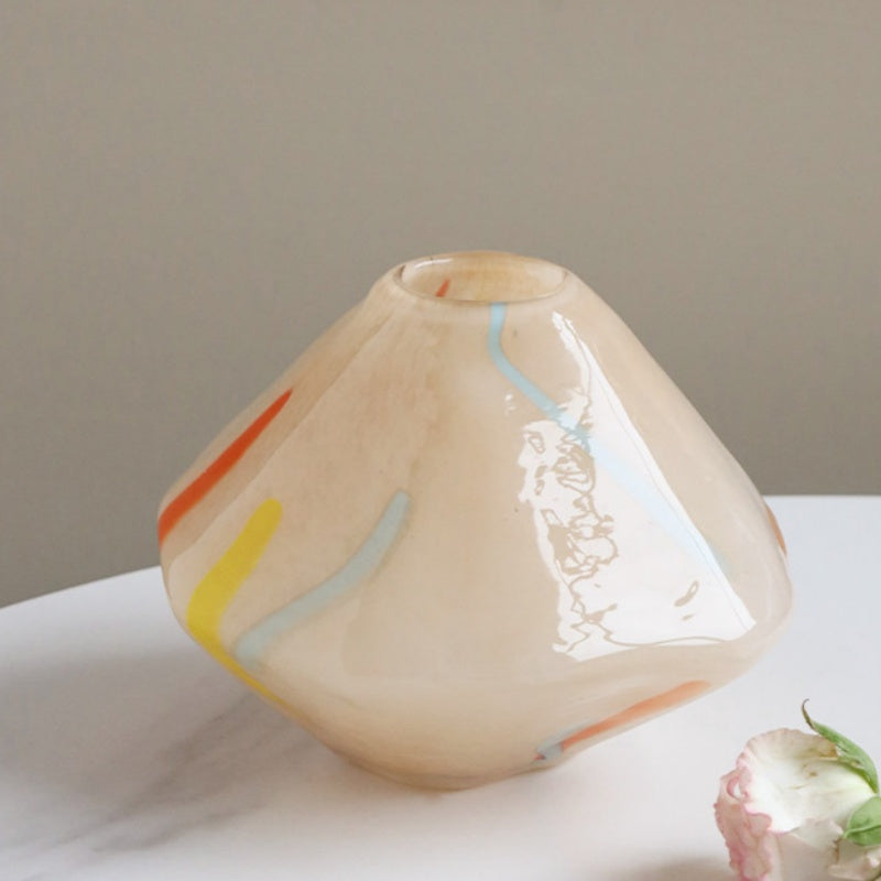 Close up of beige geometric glass vase with abstract strokes