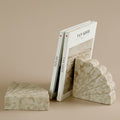 Beige marble fan bookends holding books on desk