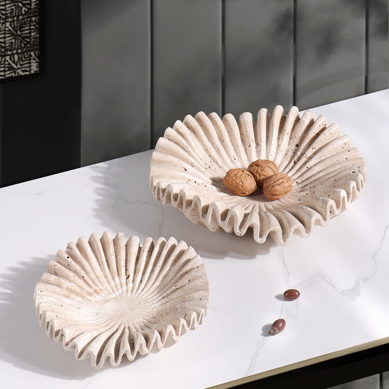 Two beige marble ruffled bowls styled on table