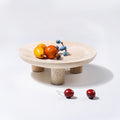 Beige travertine footed tray displaying fruit