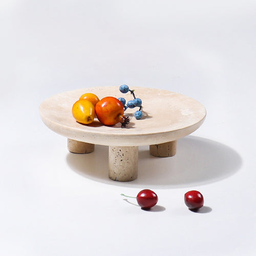 Beige travertine footed tray displaying fruit
