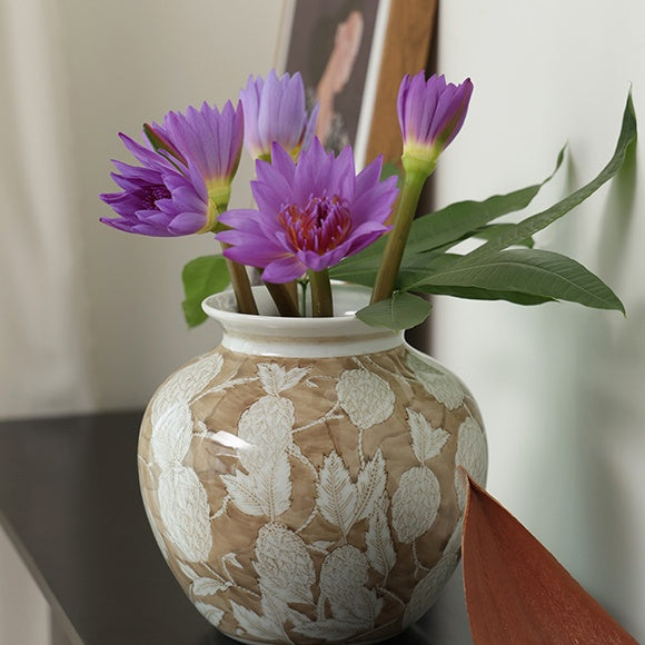 Beige and white textured ceramic vase with purple flowers