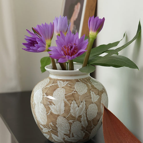 Beige and white textured ceramic vase with purple flowers