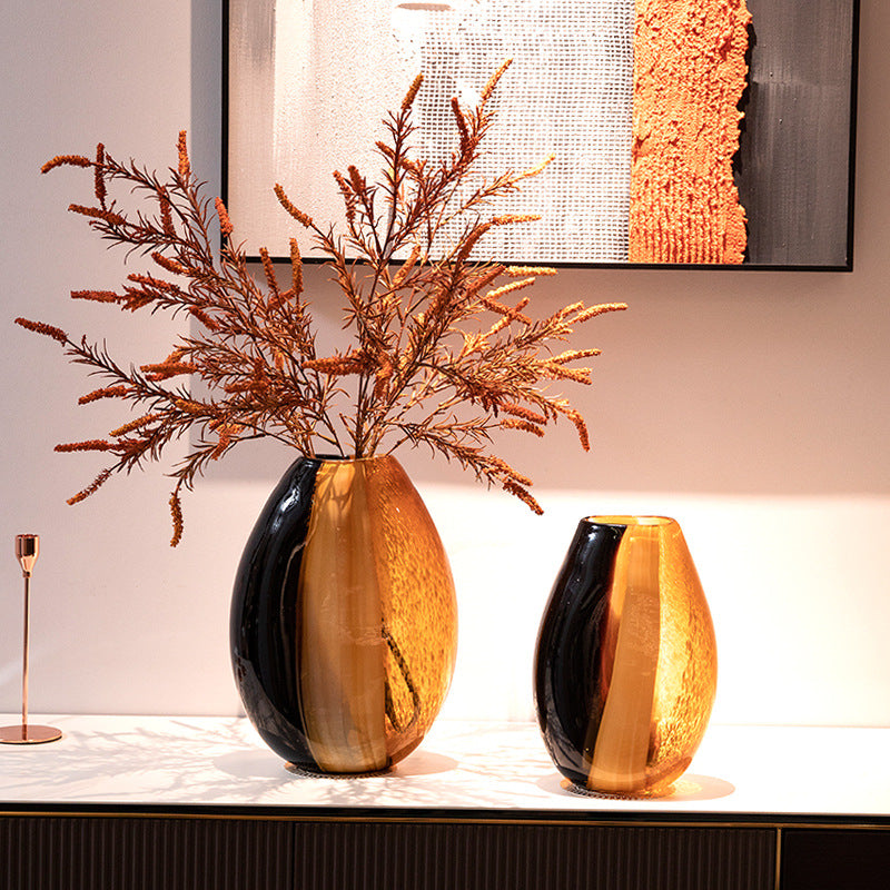 Two-tone black and amber glass vases styled with dried flowers