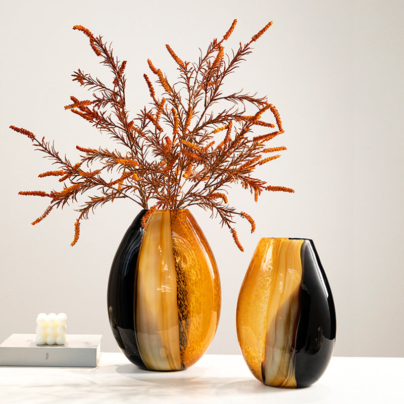 Duo of black and amber oval vases on white surface