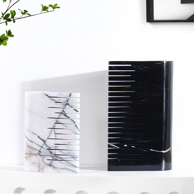 Large black marble vase and medium white marble vase standing side by side highlighting ribbed design