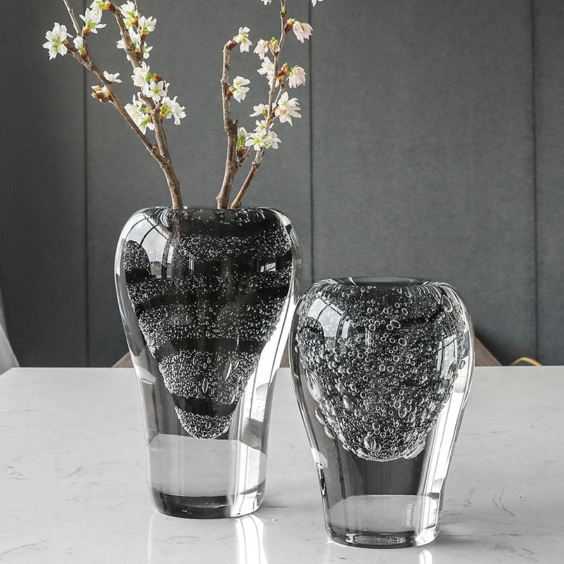 Black bubble glass vase with flowers on marble table