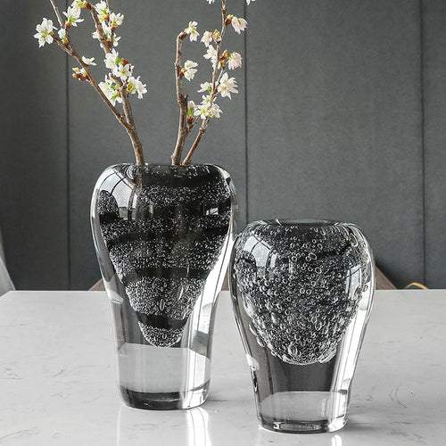 Black bubble glass vase with flowers on marble table