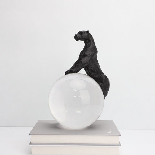 Side profile of black cast iron panther on crystal ball