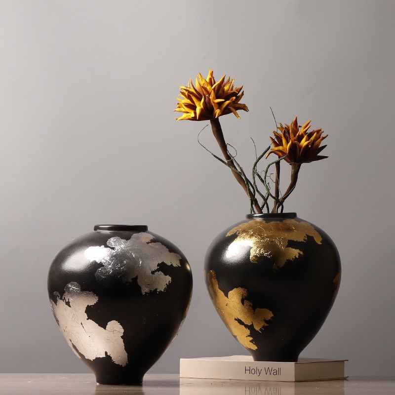 Two black ceramic vases with gold and silver details