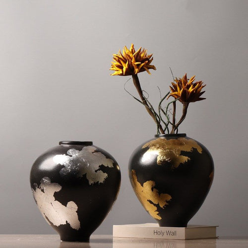 Two black ceramic vases with gold and silver details
