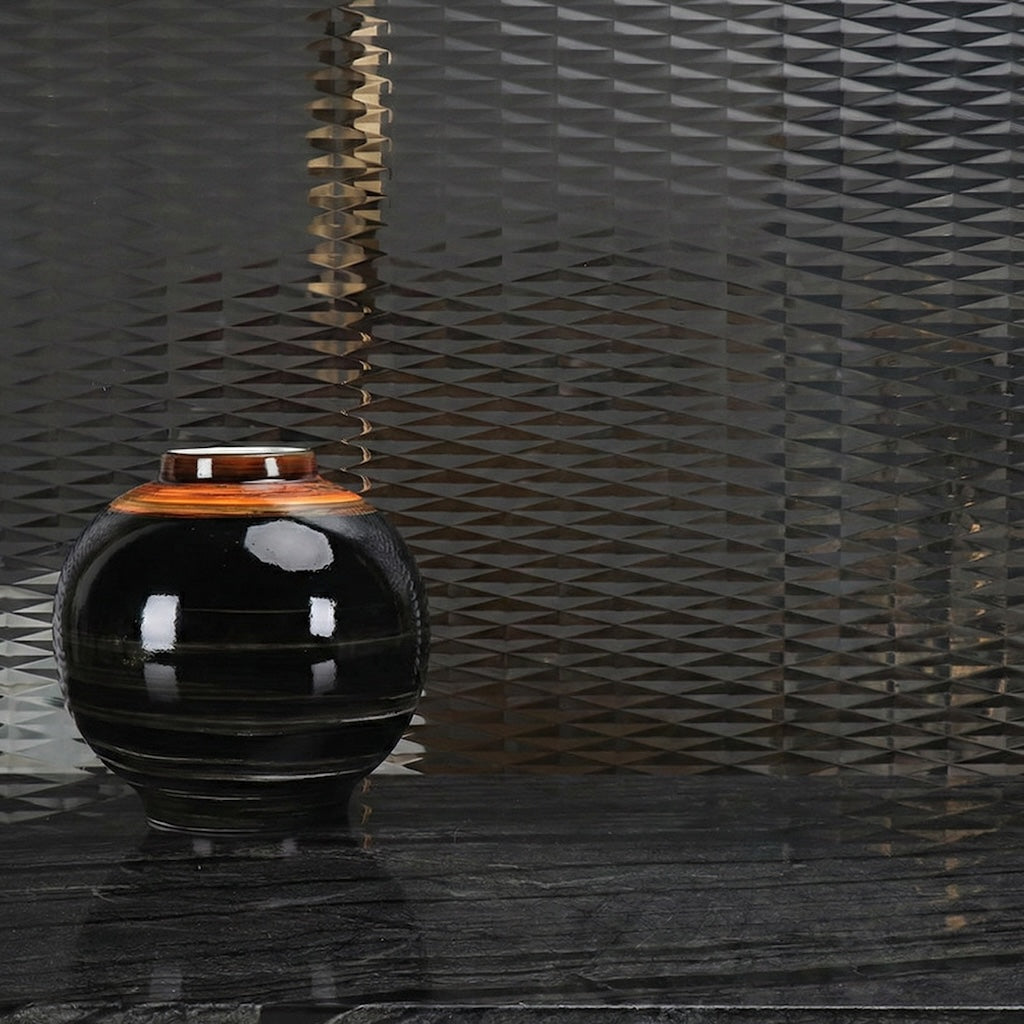 Large ribbed black ceramic vase with bronze rim detail