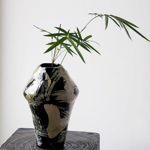 Black and cream abstract ceramic vase with green bamboo foliage