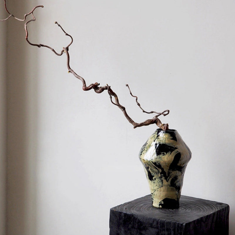 Artistic black and beige ceramic vase styled with dried branch