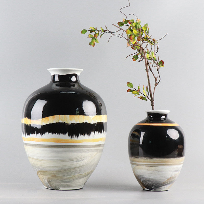 Large black and cream ceramic vase with botanical arrangement