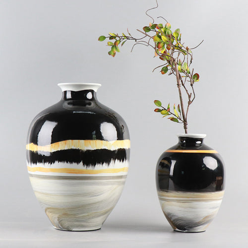 Large black and cream ceramic vase with botanical arrangement