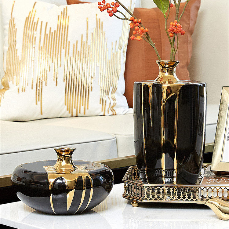 Black and gold ceramic vases with drip design on sofa table
