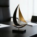 Black and gold metal sailboat sculpture on executive office desk