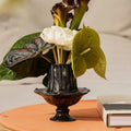 Close up of black pedestal vase with flowers