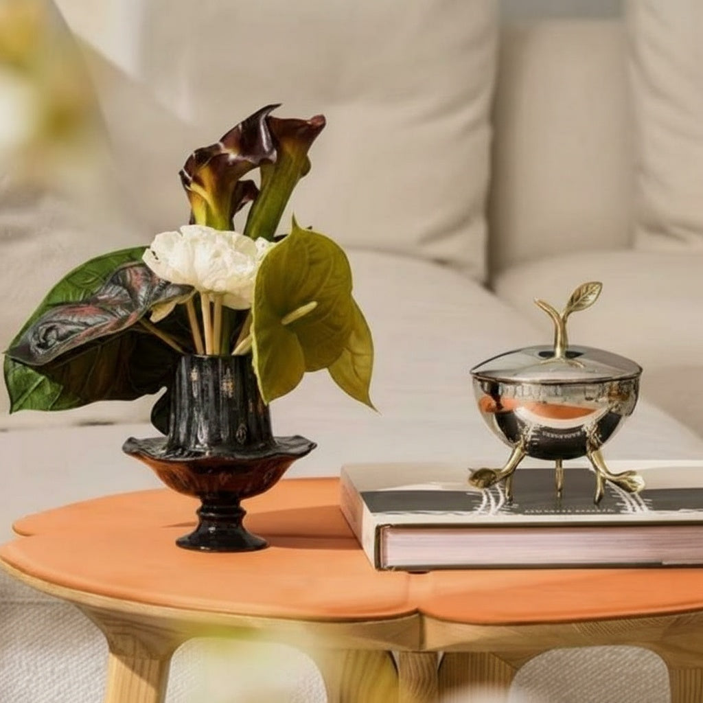 Lifestyle setting with black ceramic vase on orange table