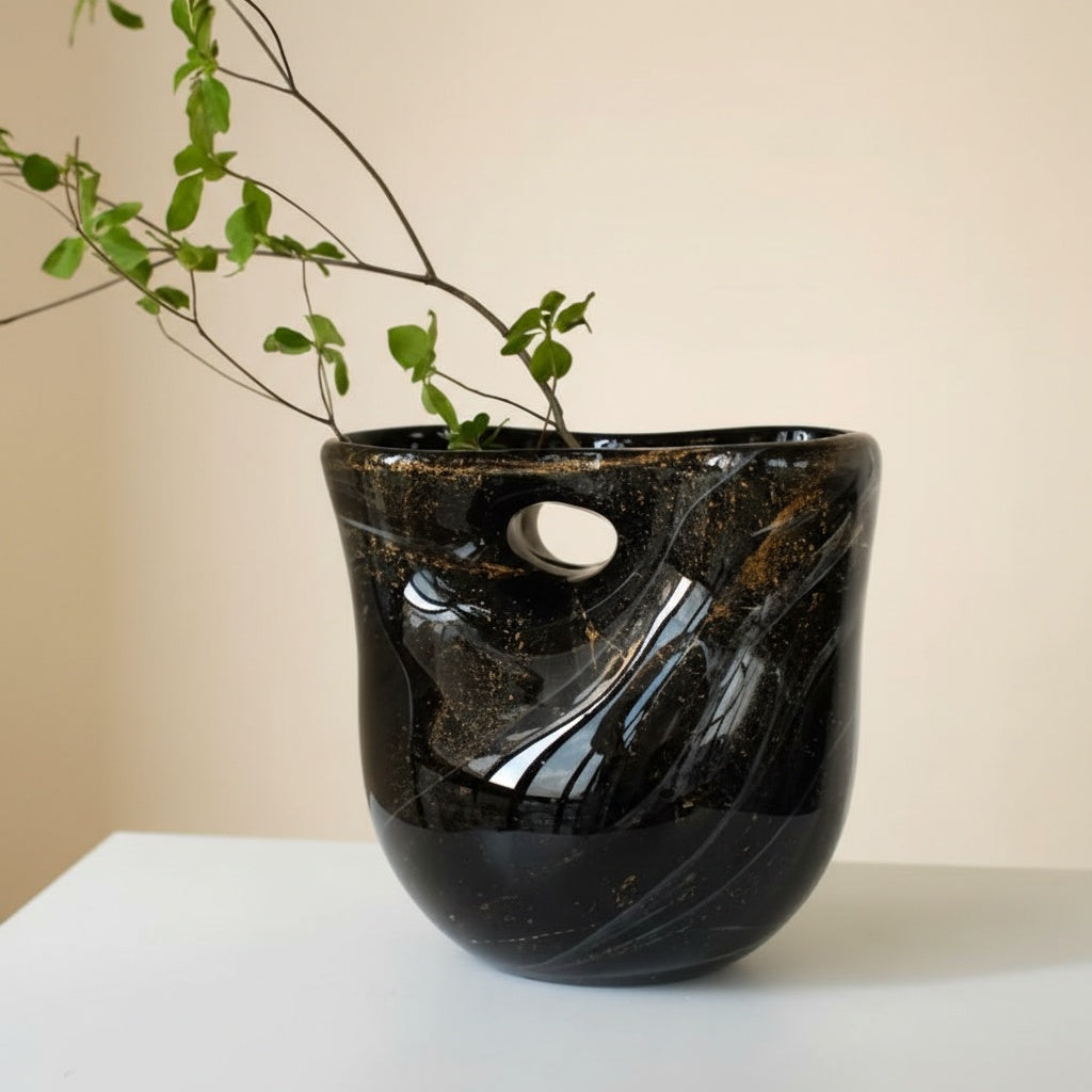 Black art glass vase with greenery styled