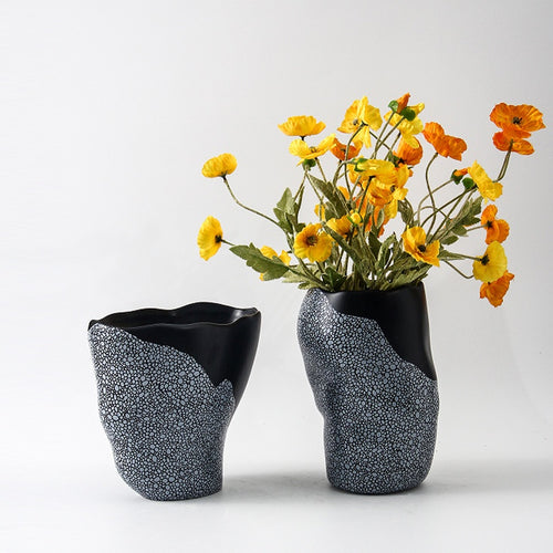 Two textured ceramic vases with yellow flowers