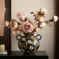 Front view of black ceramic vase with dried pink flowers