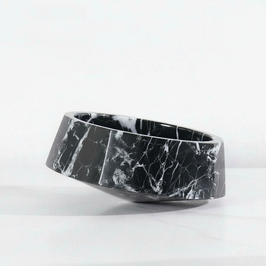 Black marble asymmetrical faceted bowl on white surface