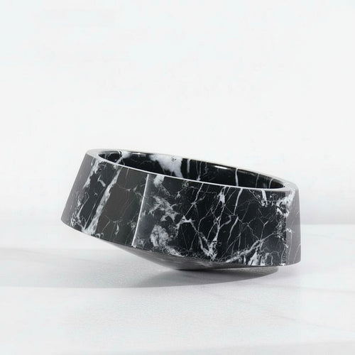 Black marble asymmetrical faceted bowl on white surface