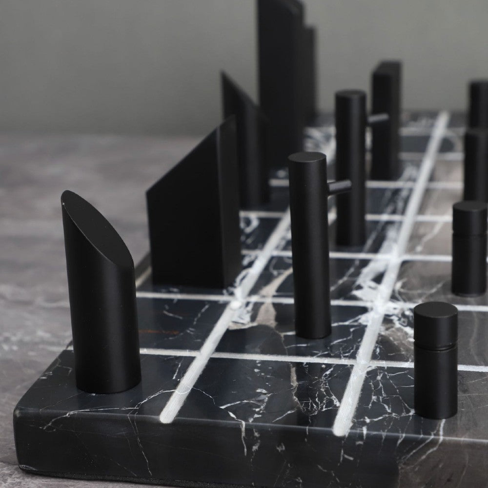 Close-up detail of black marble chess board with sculptural black pieces