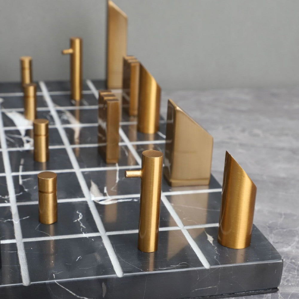 Close-up of brass chess pieces on black marble minimalist chess board