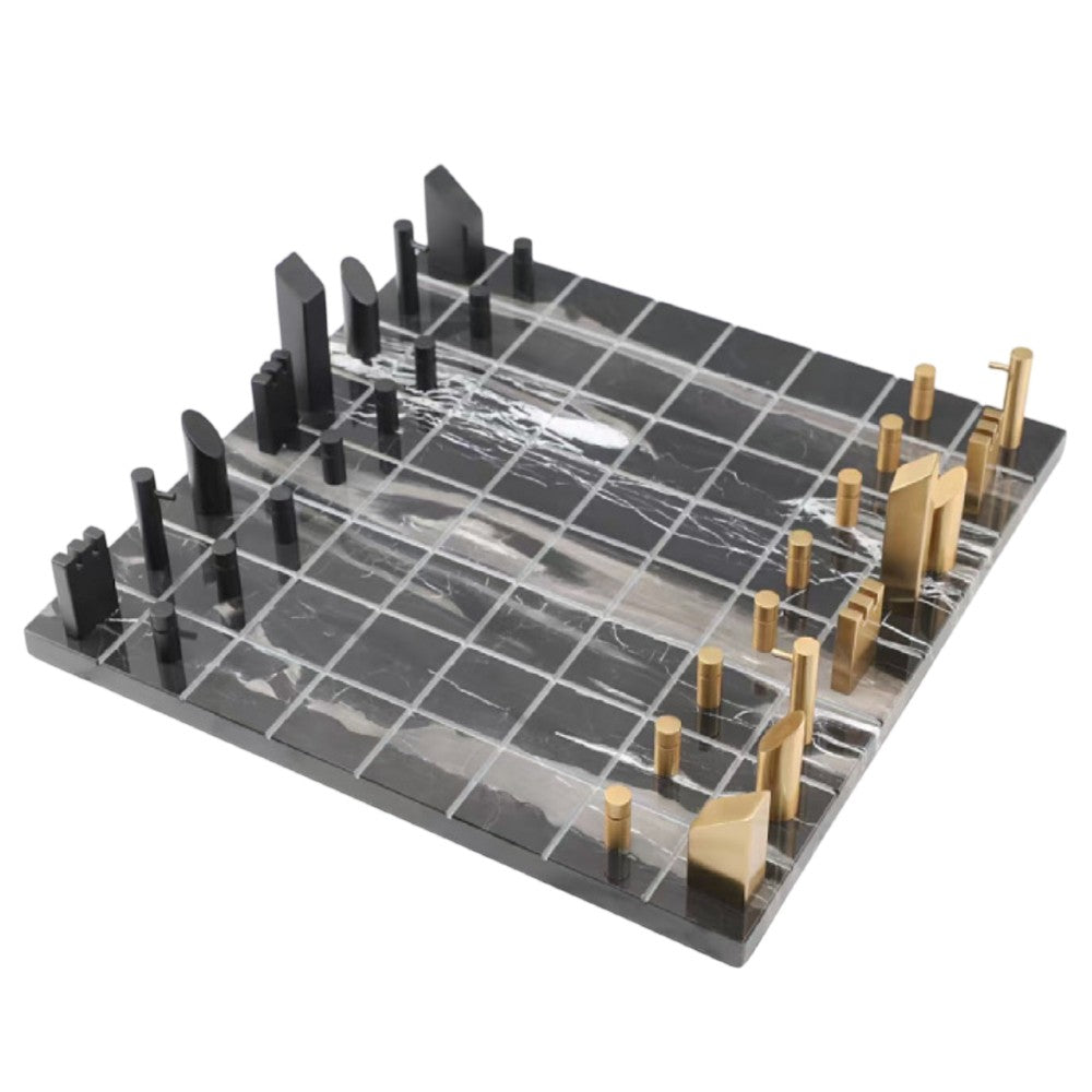 Top angled view of black marble chess board with brass and black geometric pieces
