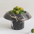 Black marble pedestal fruit bowl with limes