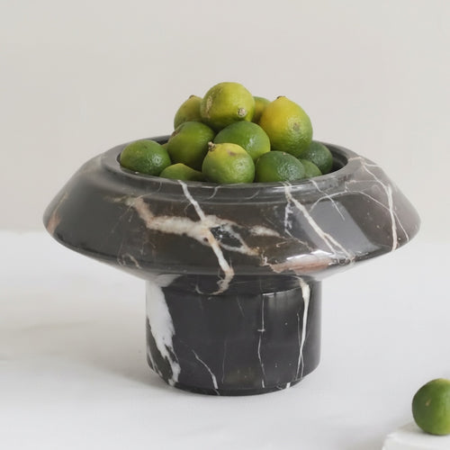 Black marble pedestal fruit bowl with limes