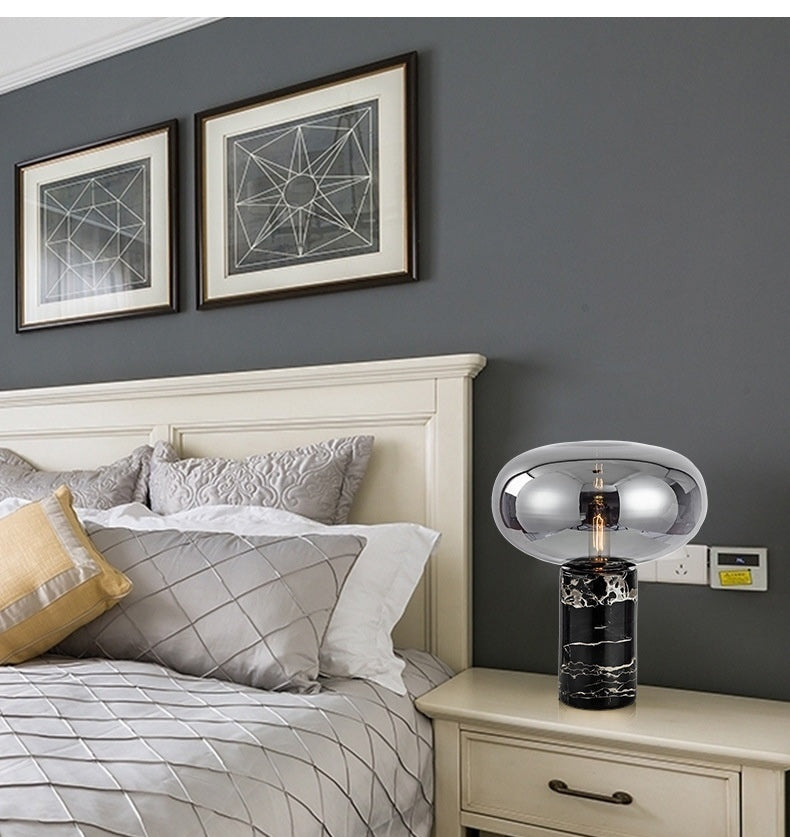 Black marble table lamp with smoked glass shade on bedside table