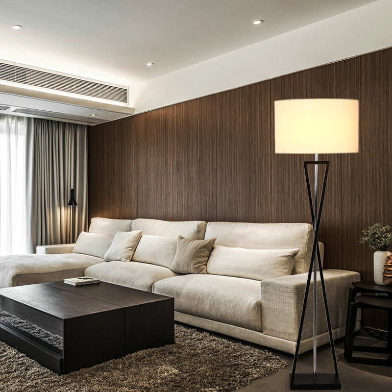 Black metal and chrome floor lamp against wood panel wall