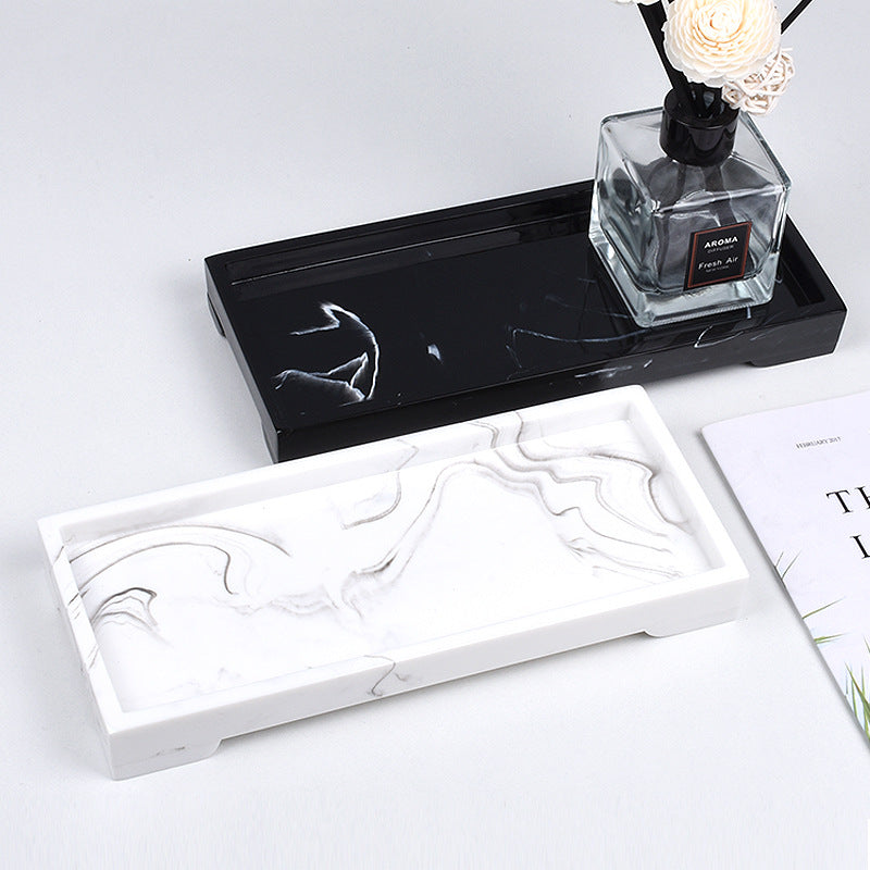 Durable black resin vanity tray with white marble veining on a white surface