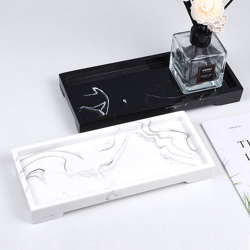 Durable black resin vanity tray with white marble veining on a white surface