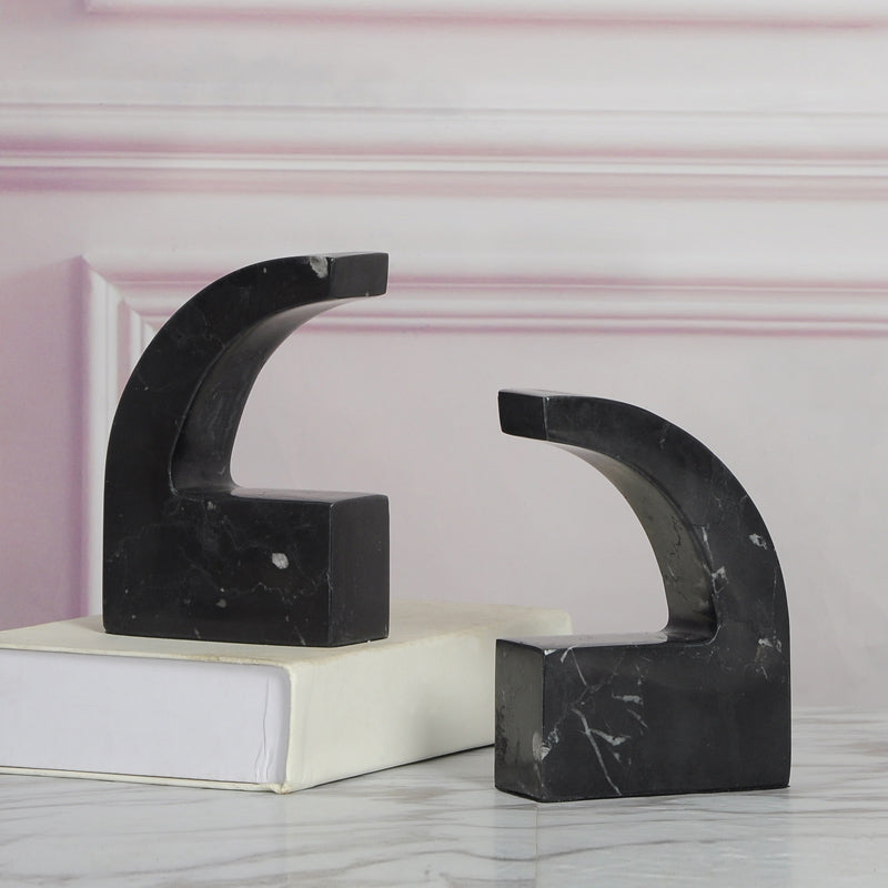 Black marble arch bookends displaying natural white veining and a sculptural curved design