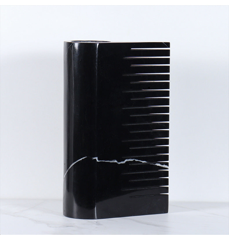 Close-up detail of black marble vase highlighting polished finish and architectural comb structure