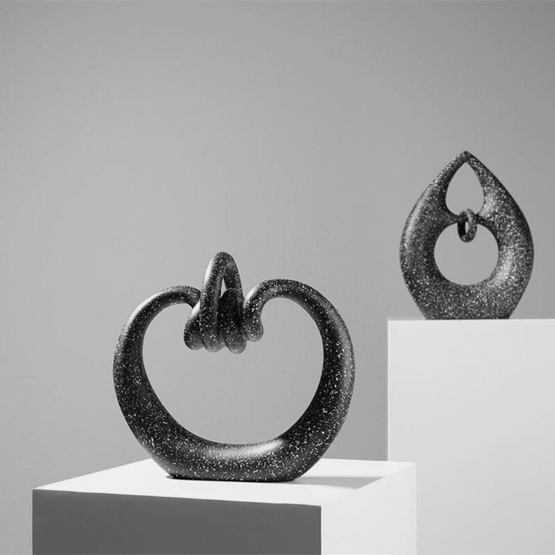 Modern abstract knot sculpture set in black speckled resin