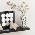 Ceramic vase with dried flowers on shelf with modern decor